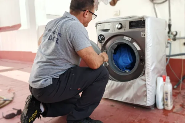 Técnico de lavadoras revisando la puerta de una lavadora LG en una azotea de Tenerife